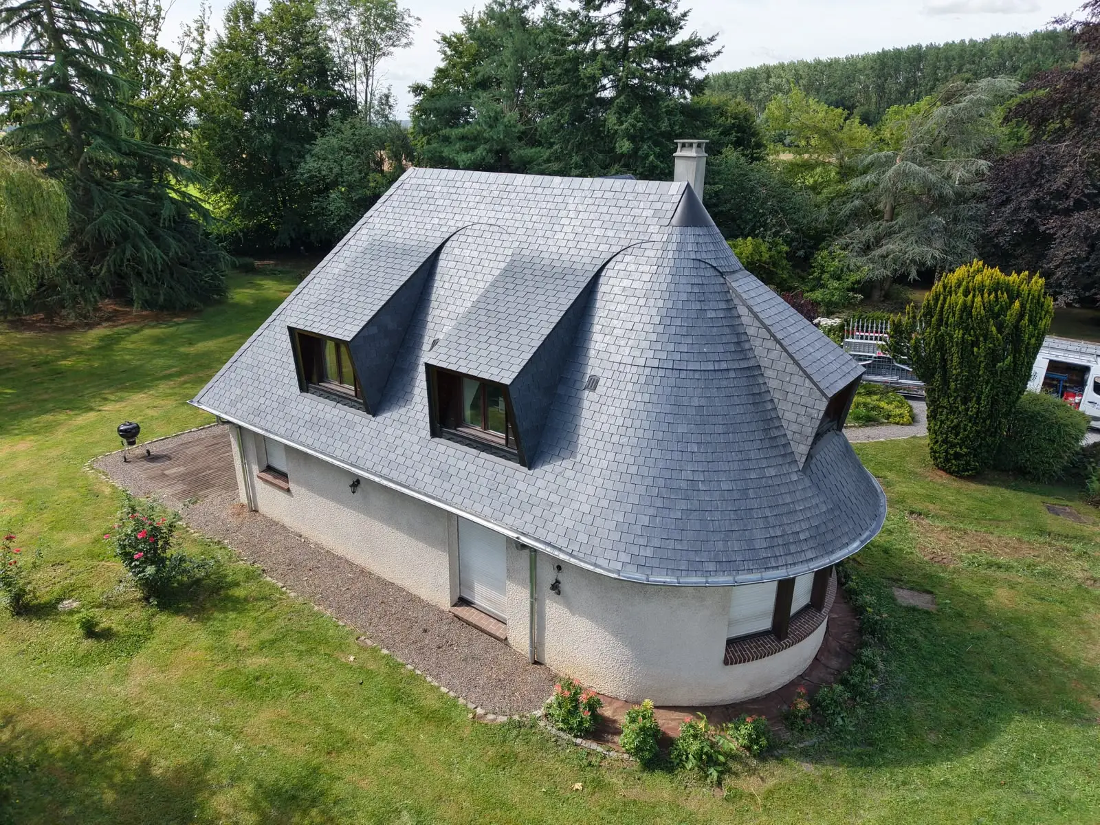 Maison avec toiture mansardée en ardoise vue depuis les airs